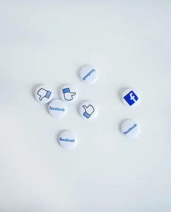 Маленькі білі кружечки з лайками та логотипом FacebookМ