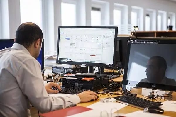 Man sitting at the workplace looking into the monitor