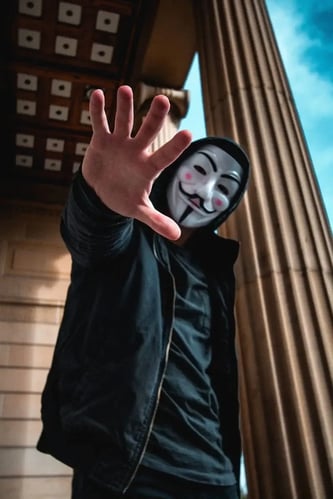 A man in a mask and a black hoodie stretched out his hand