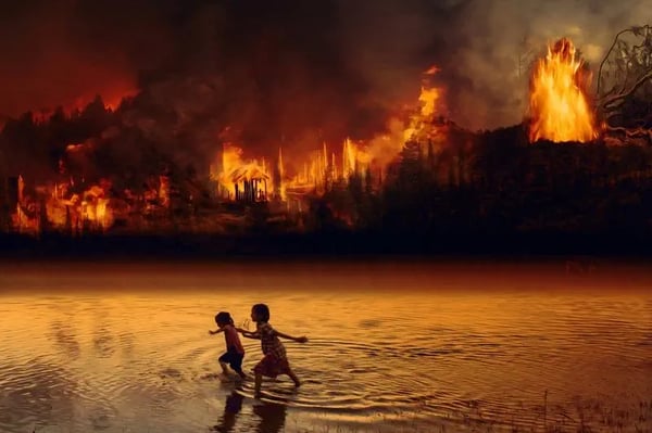 Дві дівчини біжать у воді, на фоні горить ліс