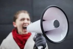 A woman shouts into a loudspeaker