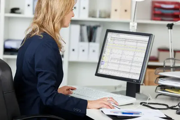 Side view portrait of businesswoman using computer at office desk 