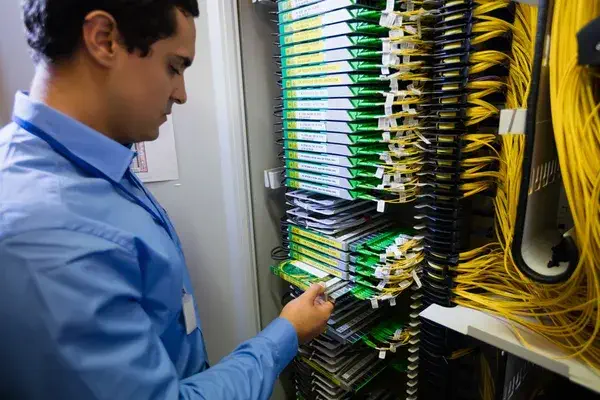 Technician checking routers in server room 